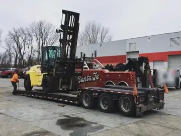 Santa Fe lowboy transporting large forklift
